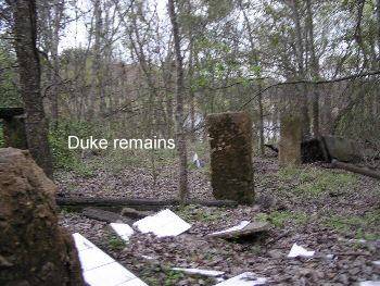 Burned hotel remains with Clear Lake in the background.